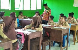 Guru madrasah sedang menjalankan tugas mengajar