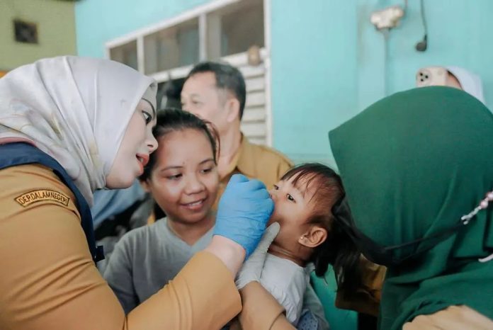 Bupati Karawang, Cellica Nurrachadiana memberikan imunisasi polio kepada anak