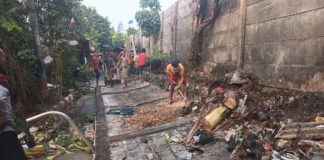 Warga merapihkan lokasi robohnya tembok pembatas rumah sakit dengan pemukiman warga di Depok (1)