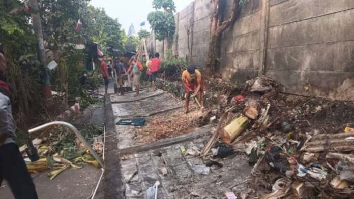 Warga merapihkan lokasi robohnya tembok pembatas rumah sakit dengan pemukiman warga di Depok (1)