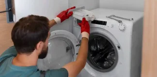 Seorang pria membersihkan mesin cuci (Foto: Freepik.com)