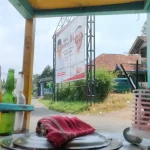 Gerobak mie ayam dan baliho salah satu bakal calon Bupati Purwakarta di satu persimpangan jalan di Desa Babakan Kecamatan Wanayasa Kabupaten Purwakarta (Foto: Jabarnews.com)