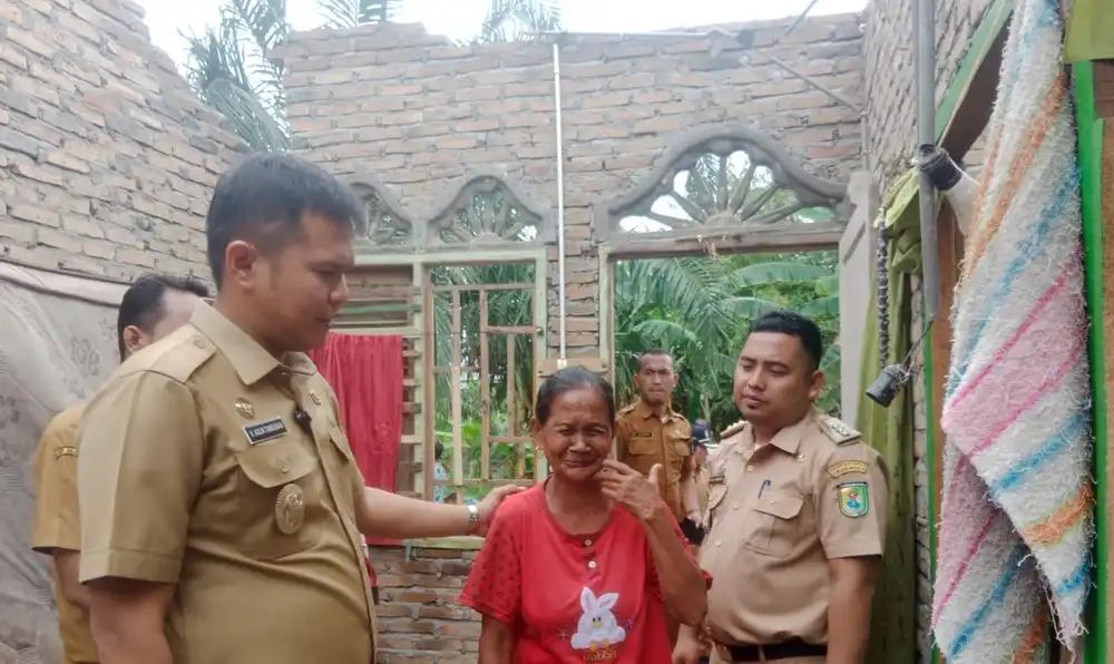 Bu Suriati menangis saat Wakil Bupati, Adlin Tambunan, mengunjungi rumahnya.