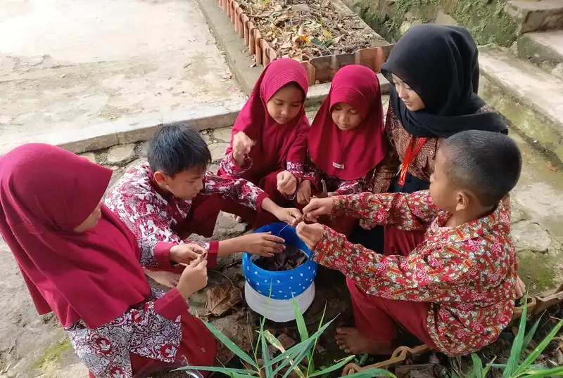 Siswa SDN 2 Sindangkasih Purwakarta mempraktikan cara mengelola sampah organik menggunakan pot komposter yang dibimbing oleh mahasiswa UPI Purwakarta (Foto: Ist)