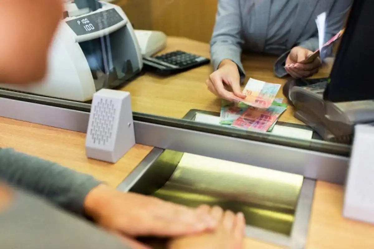 Ilustrasi nasabah melakukan transaksi perbankan di teller bank yang beroperasi dengan jadwal khusus selama libur Lebaran 2025. (Foto: Net)