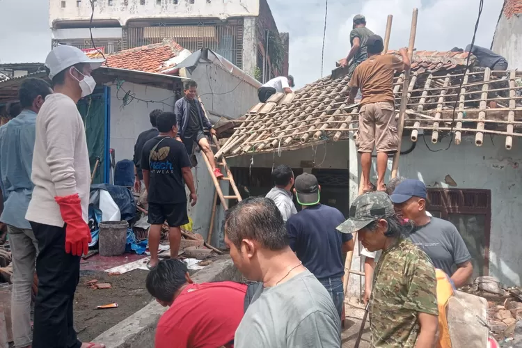 Bupati Purwakarta Om Zein bersama warga gotong royong merenovasi rumah nyaris ambruk milik mantan loper koran di Purwakarta (Foto: Kesatu.co)