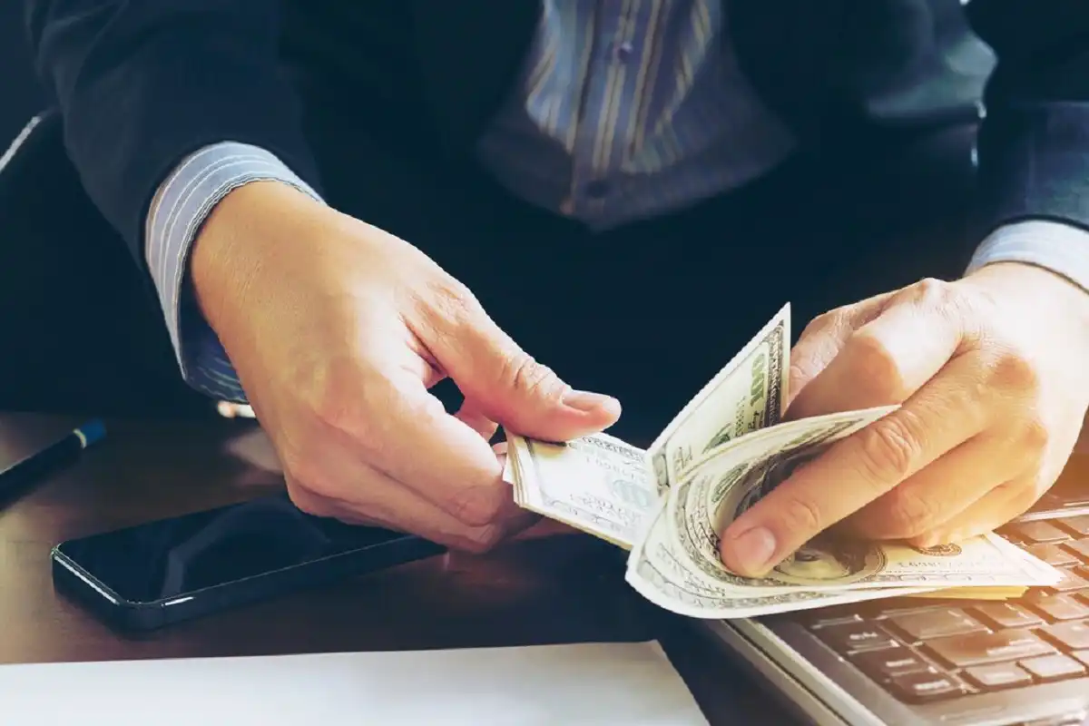 Pengusaha menghitung uang hasil penjualan dari platform digital PaDi UMKM yang bantu tingkatkan omzet hingga miliaran rupiah per tahun.