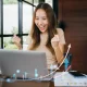 Pengusaha wanita tersenyum bahagia melihat grafik pertumbuhan bisnis di laptop, merayakan kesuksesan UMKM naik kelas berkat platform digital LinkUMKM