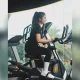 Seorang wanita tersenyum bahagia saat menggunakan elliptical trainer di gymnasium, mencerminkan filosofi mengolah raga dan jiwa untuk refleksi diri di tengah padatnya rutinitas Jabodetabek