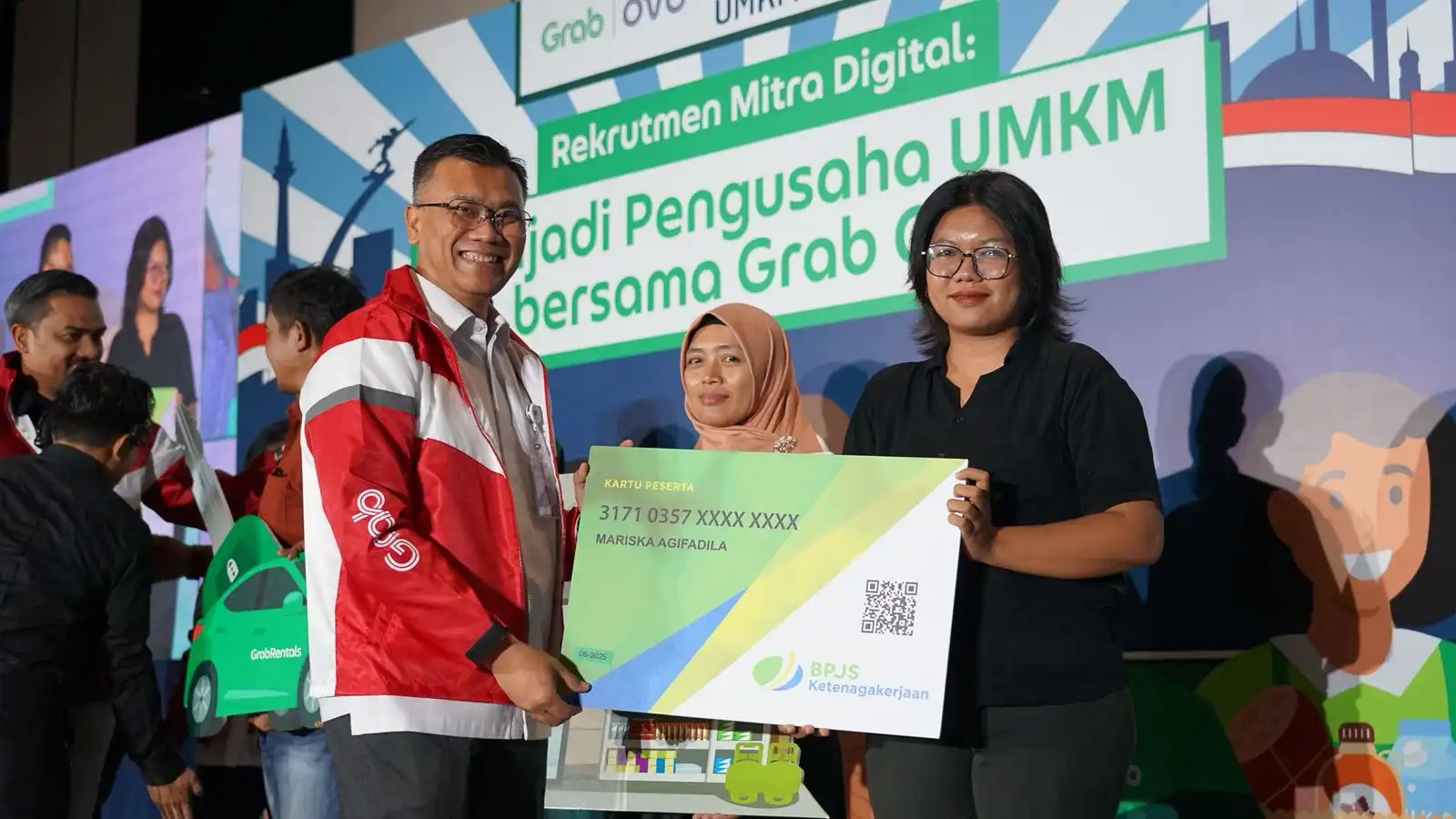 Pejabat BPJS Ketenagakerjaan menyerahkan kartu peserta kepada mitra Grab dalam program "Rekrutmen Mitra Digital: Menjadi Pengusaha UMKM Bersama Grab!" di Gedung SMESCO Indonesia, Jakarta. (Foto: BPJS Ketenagakerjaan)