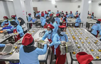Petugas dapur SPPG menyiapkan ribuan porsi makanan dalam Program Makan Bergizi Gratis yang didukung BGN dan BPJS Ketenagakerjaan.
