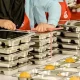 Petugas menyiapkan paket Makan Bergizi Gratis (MBG) untuk didistribusikan ke anak-anak selama libur sekolah.