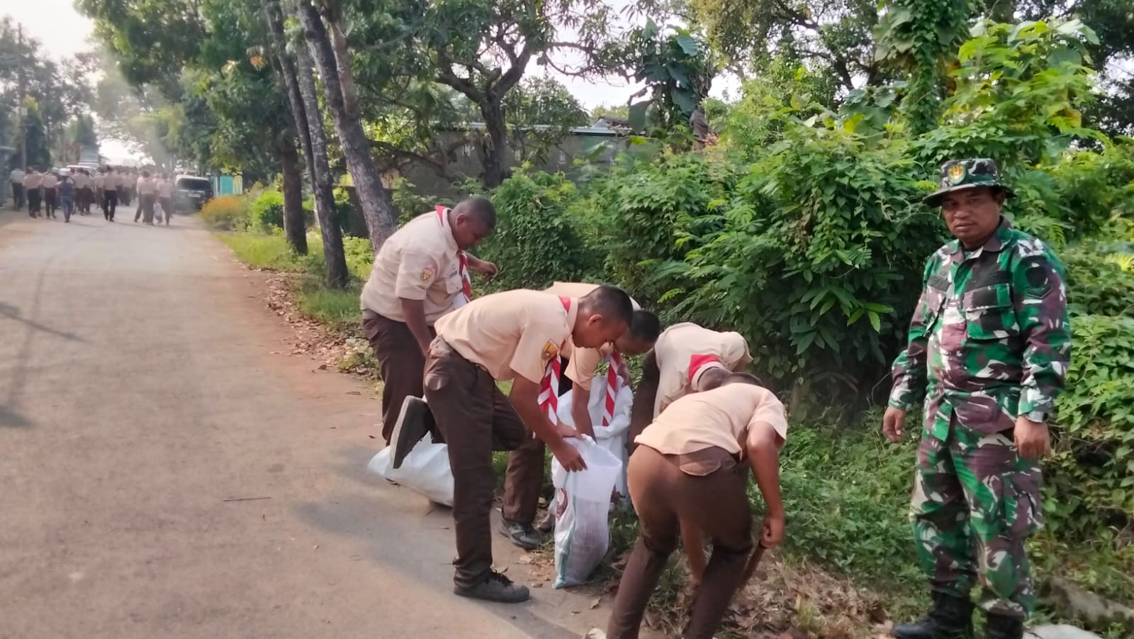 Para siswa baru SMKN Cipunagara melakukan gotong royong kebersihan lingkungan.