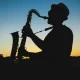Siluet pemain saksofon tampil di panggung terbuka saat matahari terbenam, menggambarkan atmosfer BRI Jazz Gunung Bromo 2025.