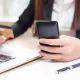Perempuan membuka deposito online bjb SiSuka melalui aplikasi DIGI bank bjb di smartphone