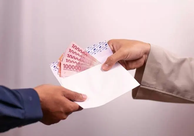 Petugas menyerahkan dana BSU 2025 secara tunai kepada pekerja melalui Kantor Pos.