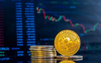 Bitcoin emas di depan grafik harga pasar crypto yang menurun.
