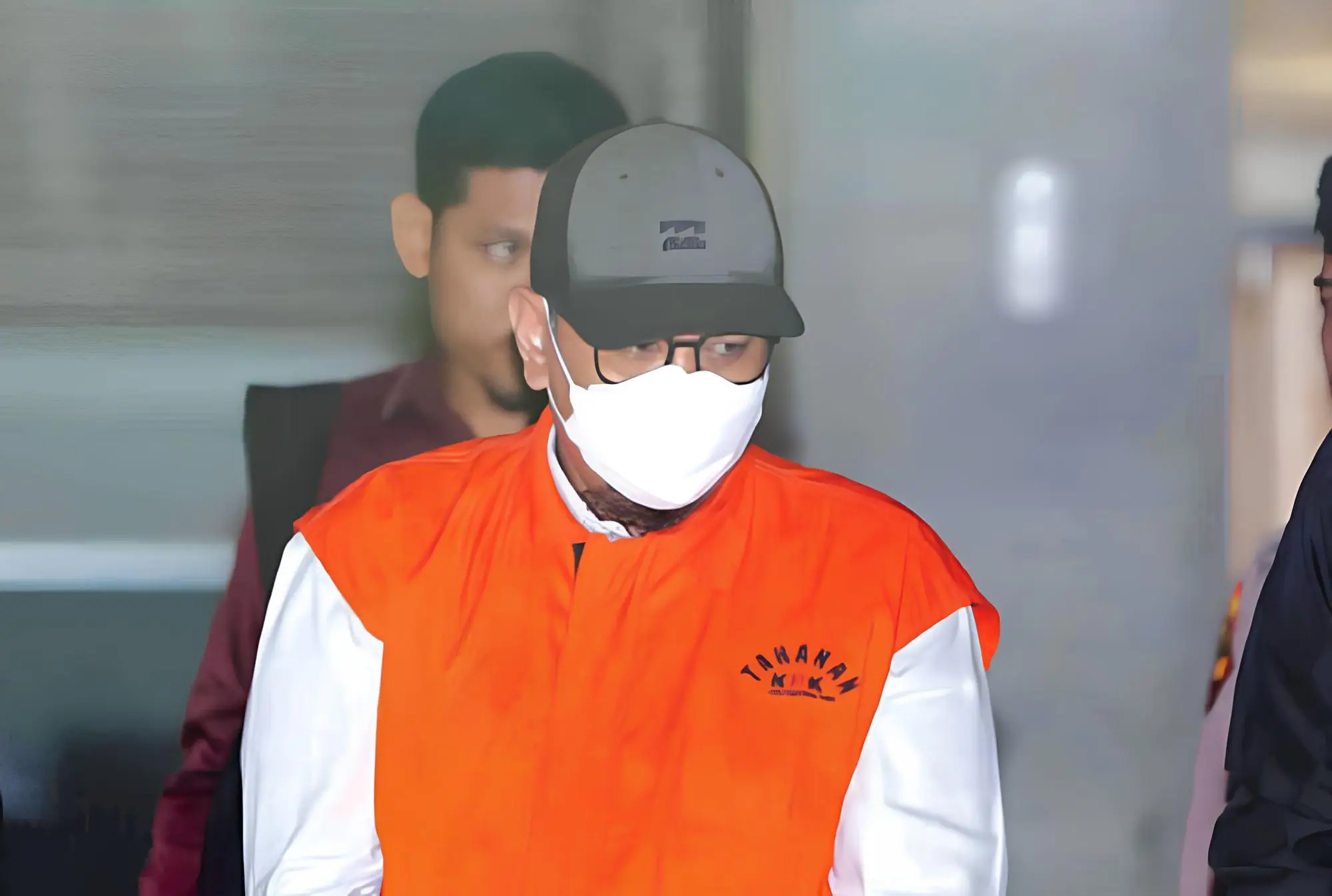 Tahanan KPK (koruptor) menggunakan masker dan topi saat digiring petugas usai pemeriksaan di Gedung Merah Putih KPK, Jakarta.