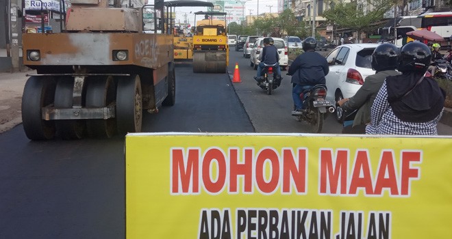 Proses perbaikan jalan rusak.