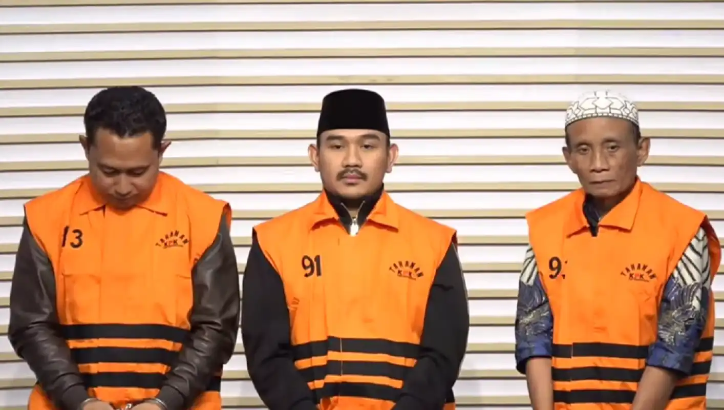 Bupati Bekasi Ade Kuswara Kunang berbaju tahanan KPK bersama HM Kunang dan Sarjan terkait kasus korupsi Bekasi.