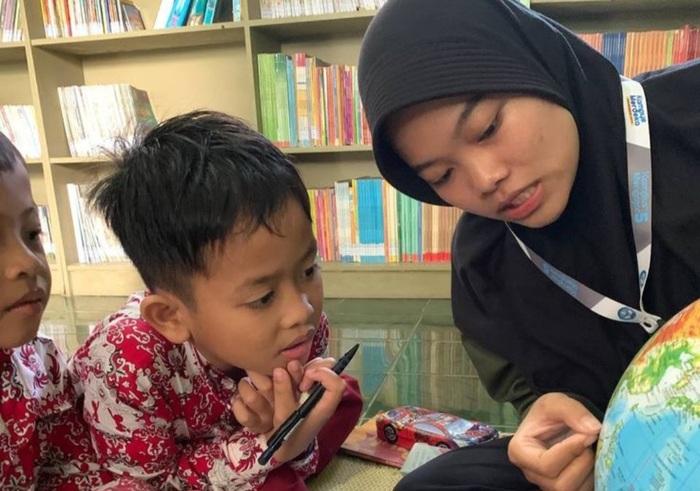 Seorang guru sedang membimbing siswanya.